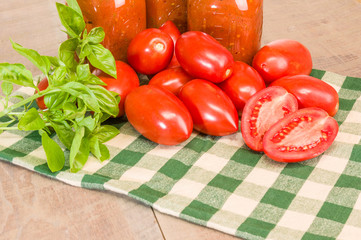 Jars of sauce with paste tomatoes and basil