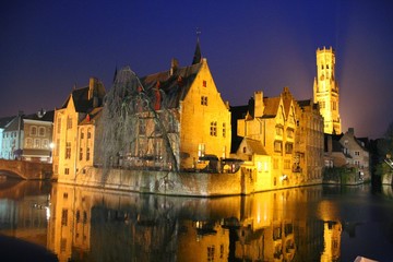 Fototapeta na wymiar Canal in Bruges with the famous Belfry in the background