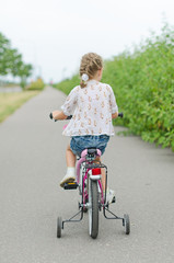 Little girl riding a bicycle in the park.