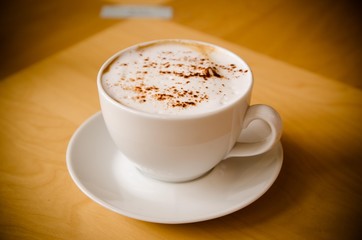 cup of cappucchino over wooden table