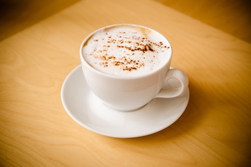 cup of cappucchino over wooden table