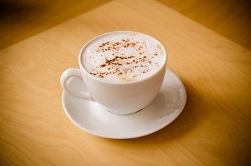 cup of cappucchino over wooden table