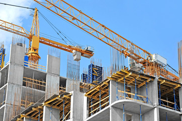 Crane and building construction site against blue sky - obrazy, fototapety, plakaty