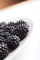 plate with blackberries isolated on white background