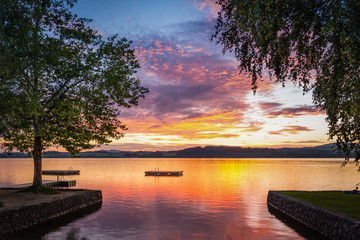 Naklejka premium moody sunset at lake wallersee in austria with trees