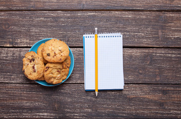 Cookie and pencil and notebook.