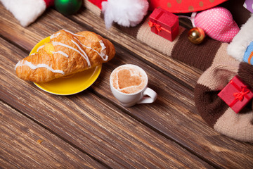 Cup of coffee and croissant on christmas background.