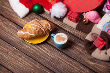 Cup of coffee and croissant on christmas background.