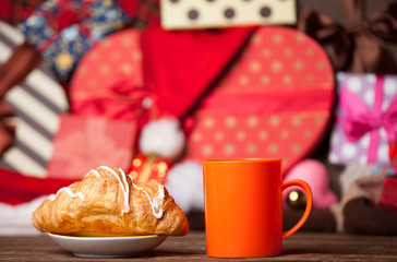 Cup of coffee and croissant on christmas background.