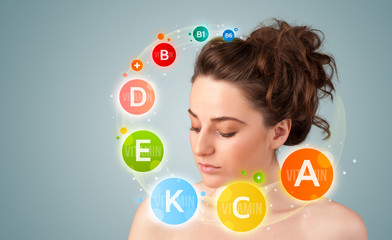 Pretty young girl with colorful vitamin icons and symbols