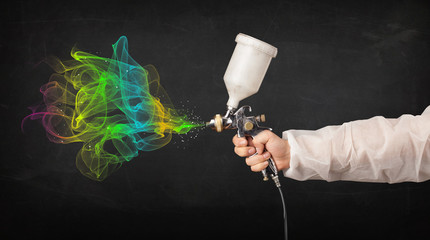 Painter working with airbrush and paints colorful paint
