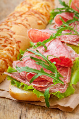 Big sandwich with salami, lettuce and arugula