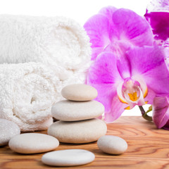 Fototapeta na wymiar Spa setting with stones, lilac orchids and towels is isolated on