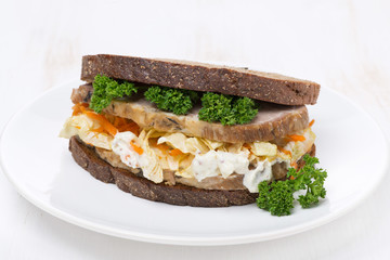 sandwich with coleslaw and baked meat on the plate