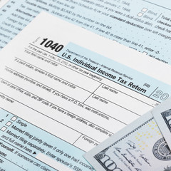 USA Tax Form 1040 with 100 US dollar bills
