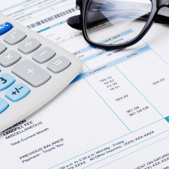 Studio shot of calculator and glasses over some receipt