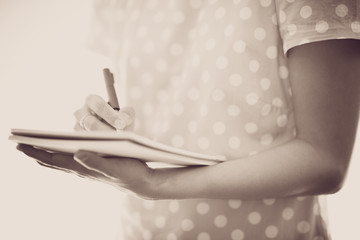 Young female is writing notes and planning her schedule