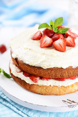 Delicious biscuit cake with strawberries on table close-up