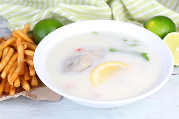 Tasty soup with oysters on wooden table
