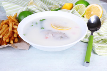 Tasty soup with oysters on wooden table