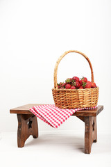 Fototapeta na wymiar Fresh strawberries in basket on white wall background