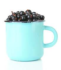 Ripe blackcurrants in mug isolated on white.