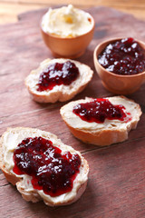 Fresh bread with homemade butter and blackcurrant jam
