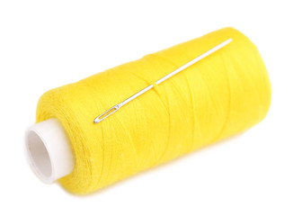 Needle and spool of thread isolated on white