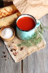 Homemade tomato juice in color mug, bread sticks, spices and