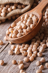 Raw chickpeas in a wooden spoon close-up  vertical