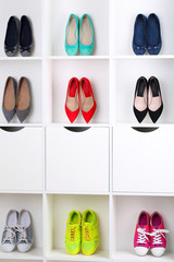 Colorful female shoes on wooden shelves
