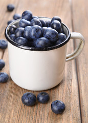 Delicious blueberries in cup on table close-up