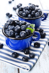 Delicious blueberries in cups on table close-up
