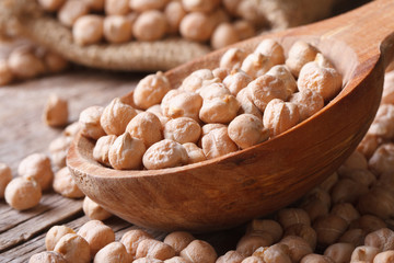 heap of raw chickpeas in a wooden spoon macro horizontal