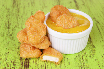 Chicken nuggets with sauce on table close-up