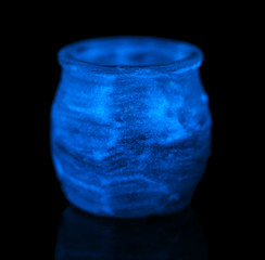 Candlestick painted fluorescent paint isolated on black
