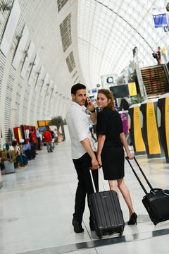 young business travelers man and woman walking in a public station