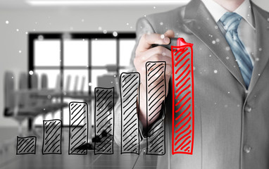 Business man drawing a growing graph