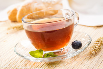 Cup of black tea with mint and fresh berries blueberry