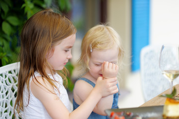 Two little sisters in outdoors cafe