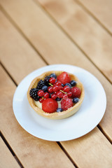 Custard fruit tart on white plate