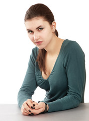 Smiling woman sitting at the desk, isolated on white background