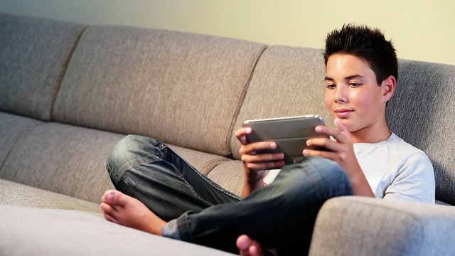 Teenager- Young boy playing from digital tablet