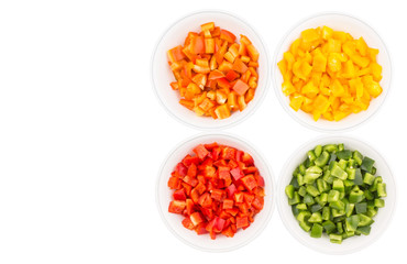 Colorful chopped capsicums in white bowls over white background