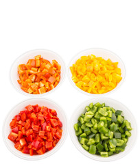 Colorful chopped capsicums in white bowls over white background