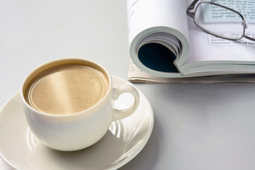 Cup of coffee near the book and glasses