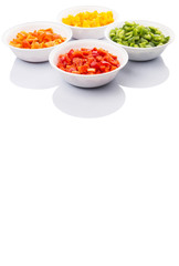 Colorful chopped capsicums in white bowls over white background