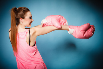 Female boxer wearing big fun pink gloves playing sports