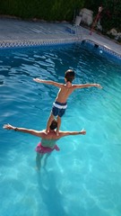 Niño haciendo equilibrio en la piscina
