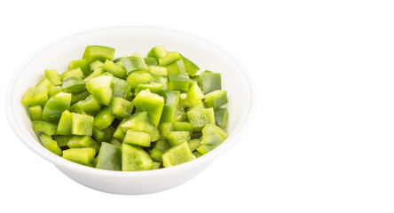 Chopped green capsicums in white bowls over white background 
